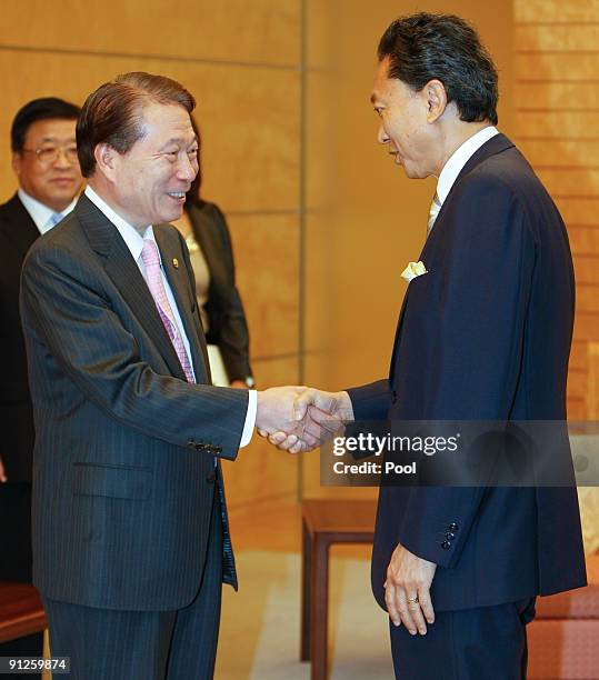 South Korean Foreign Minister Yu Myung-Hwan and Japanese Prime Minister Yukio Hatoyama shake hands prior to their meeting at Hatoyama's official...