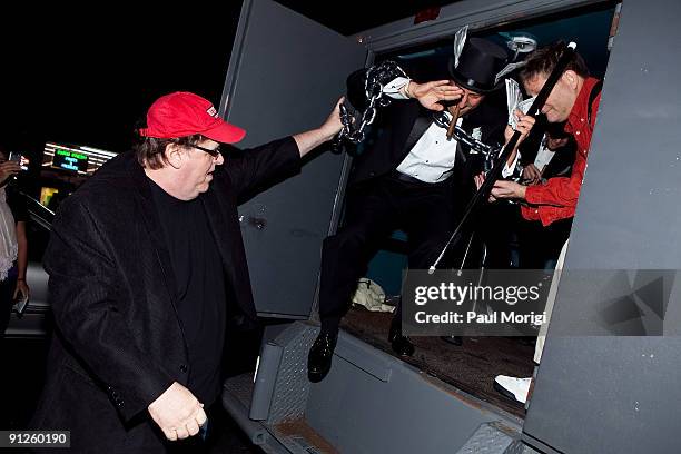 Director Michael Moore arrives with actors portraying the CEOs of three banks that received bailout money at the "Capitalism: A Love Story" premiere...