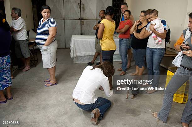 Beadie Finzi, director of the movie "Only When I Dance", plays with a dog during the film's premiere at the Complexo do Alemao Shanty Town, as part...