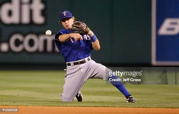 Ian Kinsler of the Texas Rangers throws from his knees to get Robb Quinlan of the Los Angeles Angels of Anaheim in the seventh inning at Angel...
