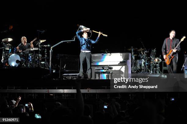 Dominic Howard, Matt Bellamy and Chris Wolstenholme of Muse perform on stage at FedExField on September 29, 2009 in Landover, Maryland.