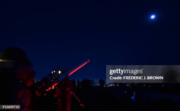 Telescopes are used for a closer view as people attend the lunar eclipse celebration at Griffith Observatory in Los Angeles, California in the early...