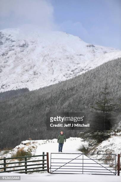 Members of the public take a walk in the snow next to the A83 Rest and Be Thankful as wintery conditions return on January 31, 2018 in Arrochar,...