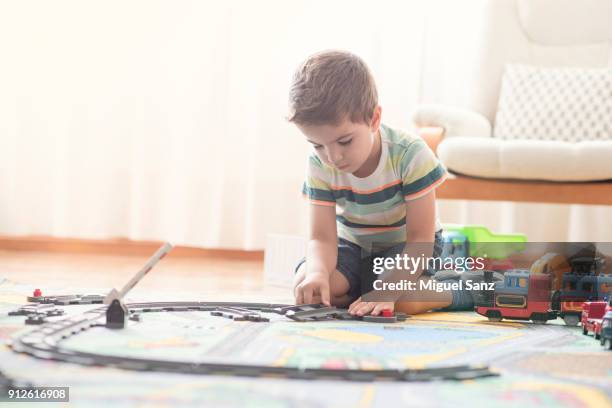 little boy, 3-4 years, playing with train and toys at home - miniature train stock pictures, royalty-free photos & images