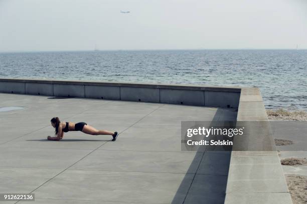 woman doing plank exercise outdoors - flatten the curve stock pictures, royalty-free photos & images