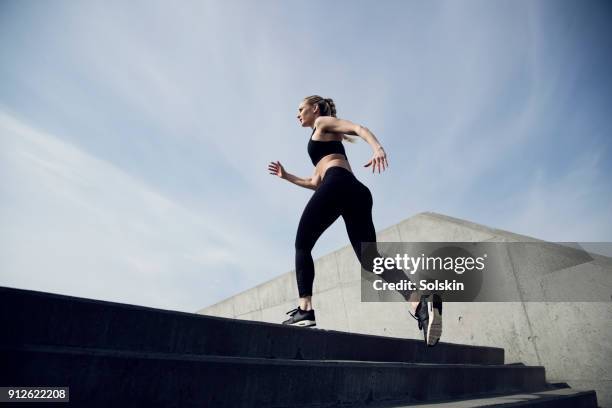 sport trained woman running outdoors - aplatir la courbe photos et images de collection