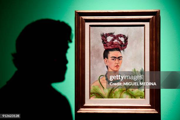 Journalist looks at a painting by Mexican artist Frida Kahlo entitled "Self portrait with Braid" during a press visit to her exhibition "Oltre il...
