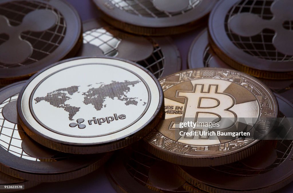 Symbol photo on the topics crypto curreny. the picture shows Ripple coins and a Bitcoin (physical).