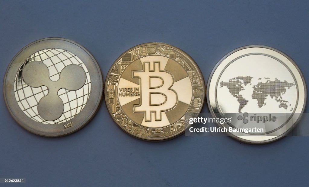 Symbol photo on the topics crypto curreny. the picture shows Ripple coins and a Bitcoin (physical).