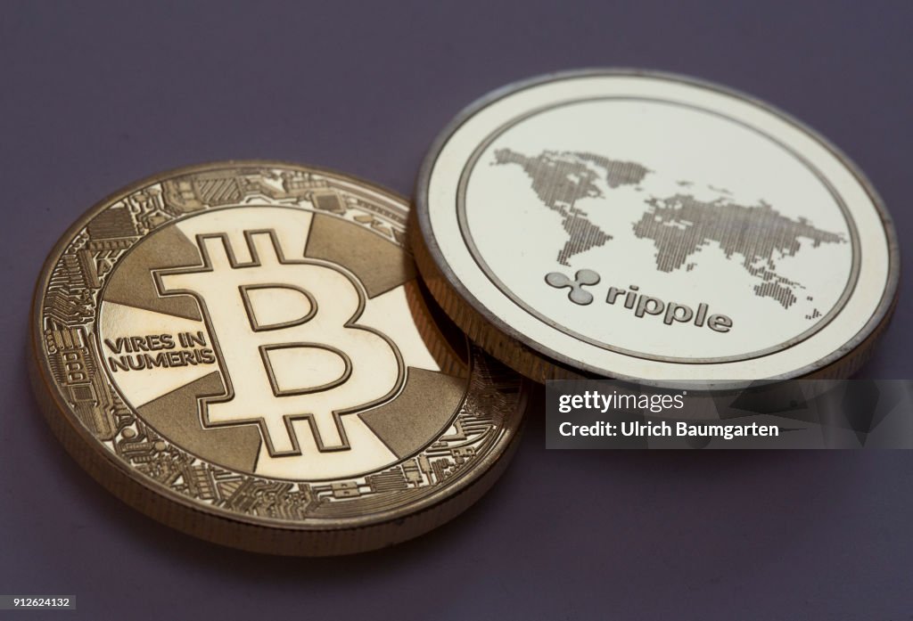 Symbol photo on the topics crypto curreny. the picture shows a Bitcoin and a Ripple coin (physical).