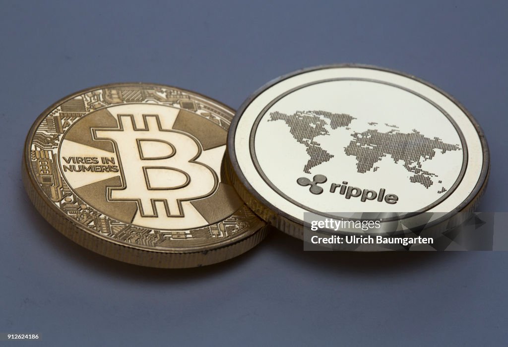 Symbol photo on the topics crypto curreny. the picture shows a Bitcoin and a Ripple coin (physical).