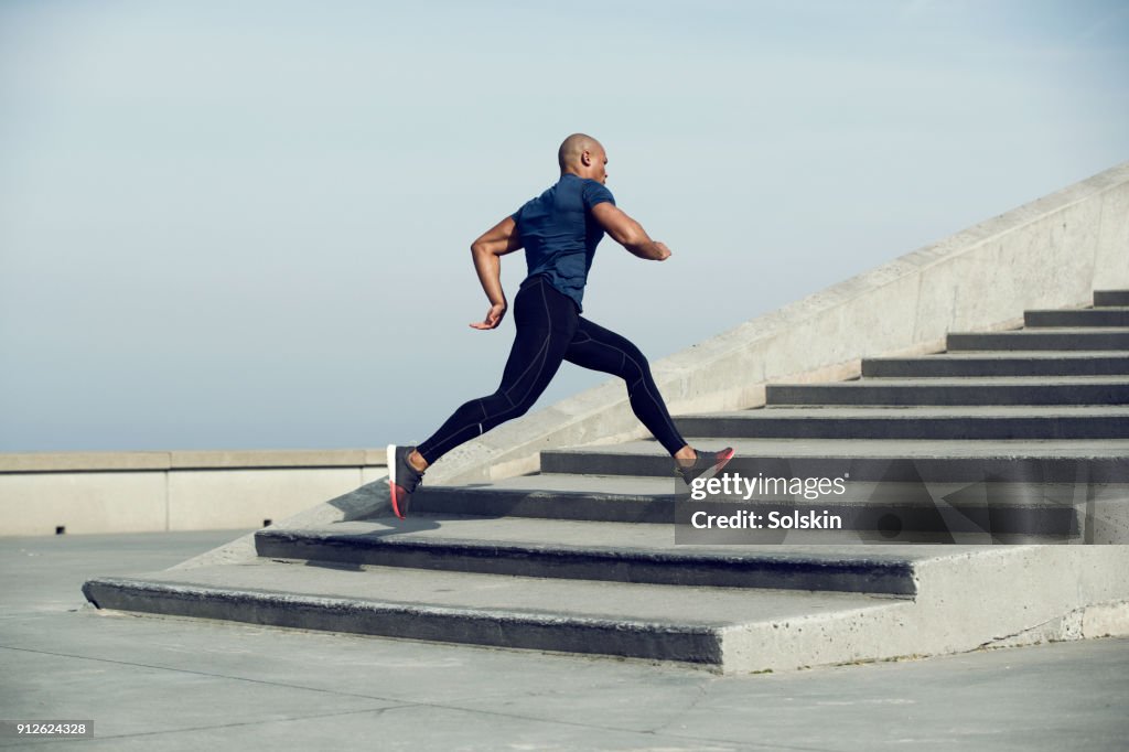 Male athlete running up steps outdoors