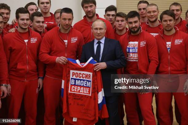 Russian President Vladimir Putin poses for a photo with national Olympic athletes who will take part in the upcoming 2018 Pyeongchang Winter Olympic...