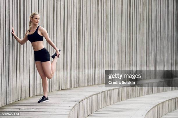 woman stretching leg after exercise - kurve abflachen stock-fotos und bilder