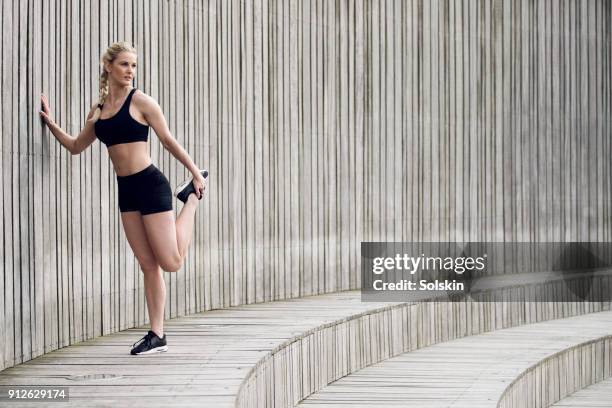 woman stretching leg after exercise - aplatir la courbe photos et images de collection