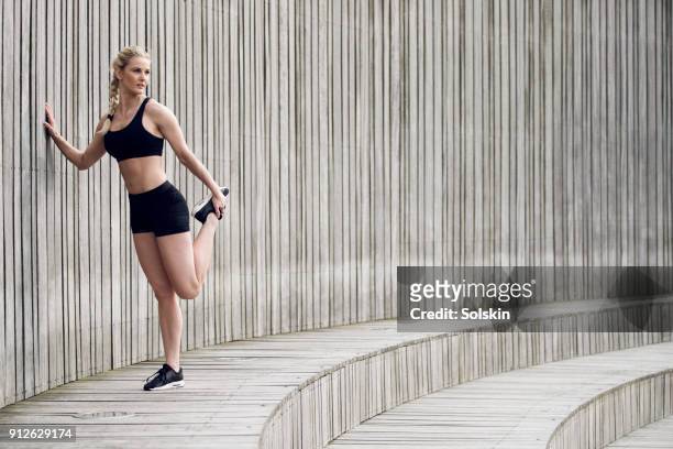 woman stretching leg after exercise - flatten the curve imagens e fotografias de stock