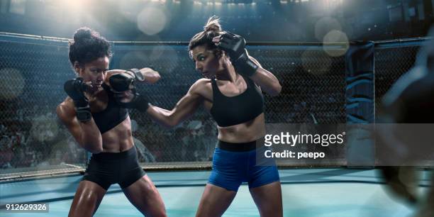 profesional femenino las artes marciales mixtas peleadores lanzan golpes en octágono - mixed martial arts fotografías e imágenes de stock