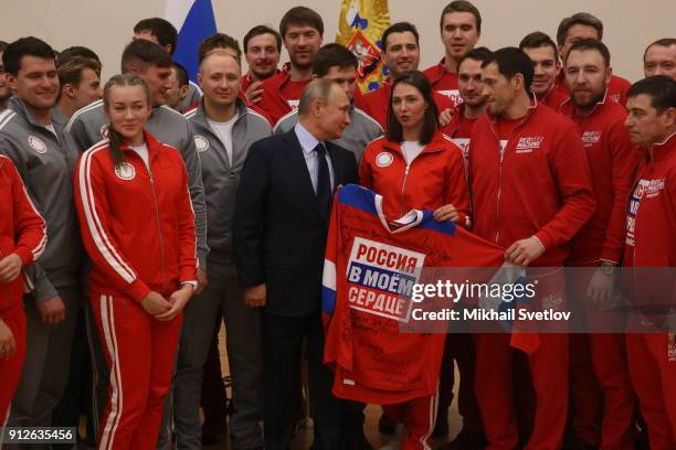 Russian President Vladimir Putin poses for a photo with Olympic athletes who will take part in the upcoming 2018 Pyeongchang Winter Olympic Games, on...