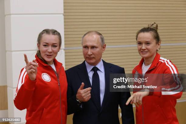 Russian President Vladimir Putin poses for a photo with Olympic athletes who will take part in the upcoming 2018 Pyeongchang Winter Olympic Games, on...