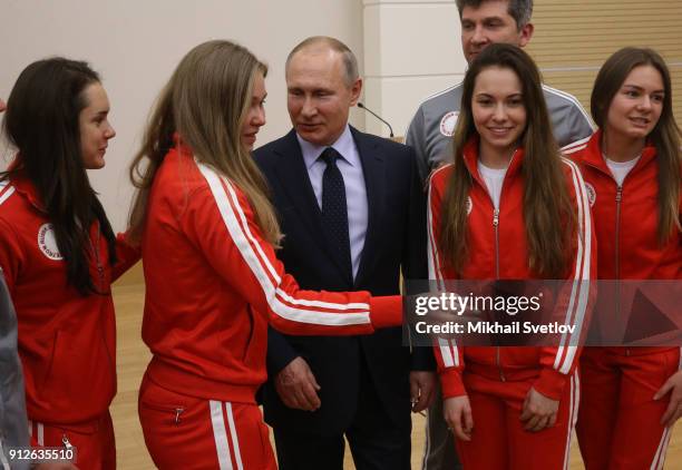 Russian President Vladimir Putin poses for a photo with Olympic athletes who will take part in the upcoming 2018 Pyeongchang Winter Olympic Games, on...