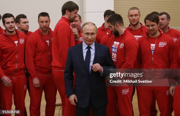 Russian President Vladimir Putin poses for a photo with Olympic athletes who will take part in the upcoming 2018 Pyeongchang Winter Olympic Games, on...