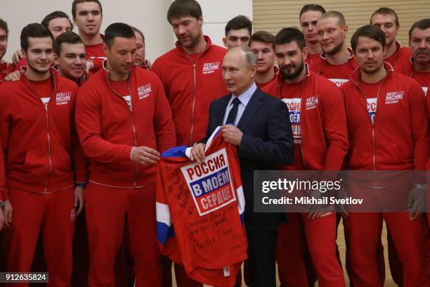 Russian President Vladimir Putin poses for a photo with Olympic athletes who will take part in the upcoming 2018 Pyeongchang Winter Olympic Games, on...