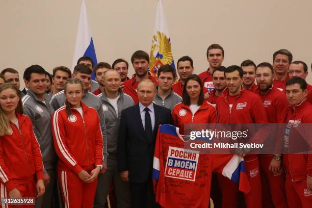 Russian President Vladimir Putin poses for a photo with Olympic athletes who will take part in the upcoming 2018 Pyeongchang Winter Olympic Games, on...