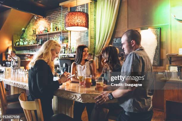 coworkers hanging out in a bar, happy hour time - cocktail party work stock pictures, royalty-free photos & images