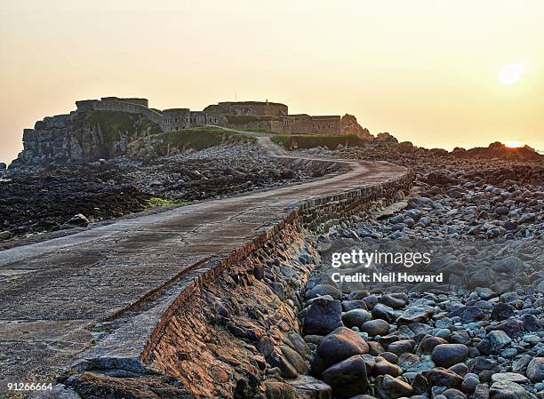 causeway to victorian fort at low tide, at sunset - island of alderney stock pictures, royalty-free photos & images