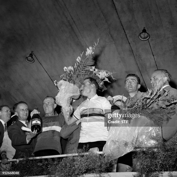 Italian cyclist Ercole Baldini flanked by French cyclists Louison Bobet and Andre Darrigade puts his rainbow jersey after winning the men's Road race...