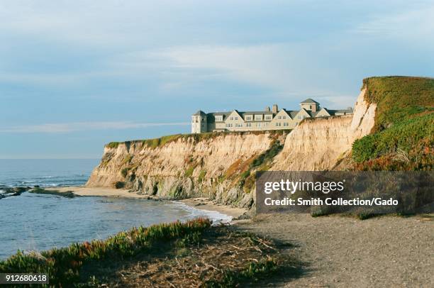 Ritz Carlton Half Moon Bay, a luxury hotel in Half Moon Bay, California, is visible atop striking cliffs above the Pacific Ocean on a sunny day,...