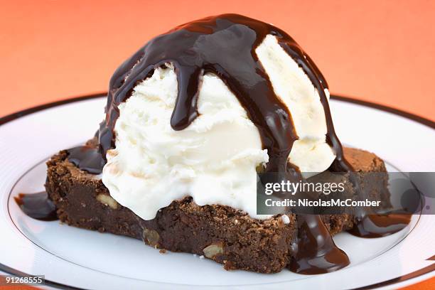 brownie with vanilla ice cream and hot fudge sauce - fudge sauce stock pictures, royalty-free photos & images