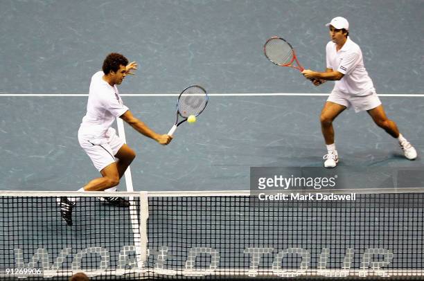 Jo-Wilfried Tsonga of France plays a backhand volley with Fabrice Santoro of France in their doubles match against Travis Parrott of the USA and...