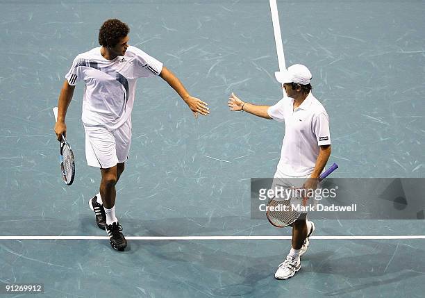 Jo-Wilfried Tsonga of France is encouraged by partner Fabrice Santoro of France in their doubles match against Travis Parrott of the USA and Filip...