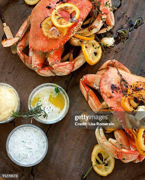 fire roasted dungeness crabs on wooden table - crab seafood stockfoto's en -beelden