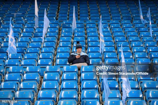 Man City fan sits alone before the Premier League match between Manchester City and West Bromwich Albion at the Etihad Stadium on January 31, 2018 in...