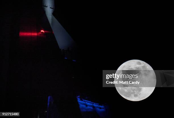 Super Blue Blood Moon rises above the Spinnaker Tower in Portsmouth on January 31, 2018 in Portsmouth, United Kingdom. A Super Blue Blood Moon is the...