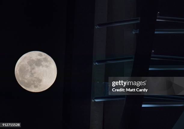 Super Blue Blood Moon rises above the Spinnaker Tower in Portsmouth on January 31, 2018 in Portsmouth, United Kingdom. A Super Blue Blood Moon is the...