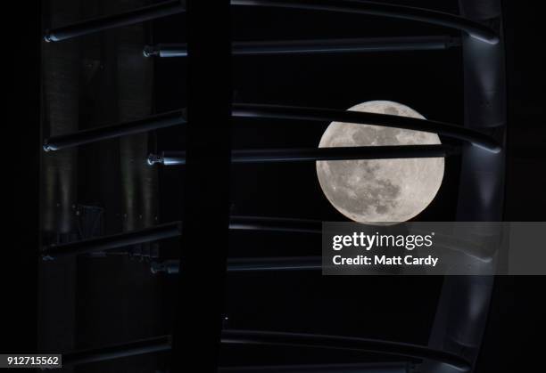 Super Blue Blood Moon rises above the Spinnaker Tower in Portsmouth on January 31, 2018 in Portsmouth, United Kingdom. A Super Blue Blood Moon is the...