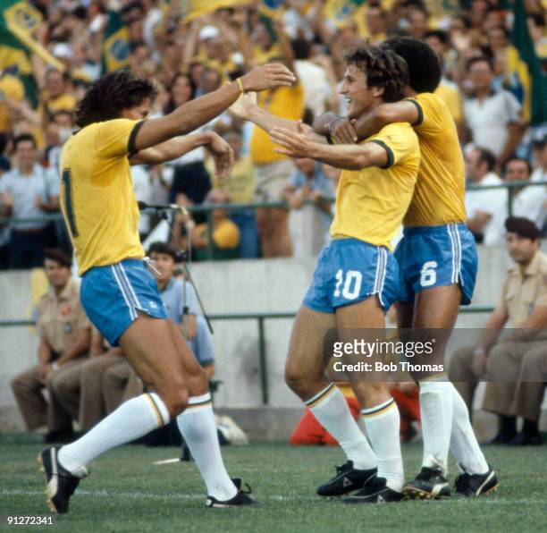 Zico of Brazil celebrates with team-mates Eder and Junior after scoring a goal during the Brazil v New Zealand World Cup match played in Seville,...