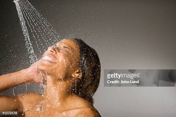 shower stream of water on models face - ducharse fotografías e imágenes de stock