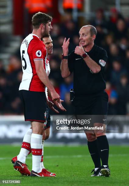 Cedric Soares and teammate Jack Stephens of Southampton confront referee Mike Dean during the Premier League match between Southampton and Brighton...