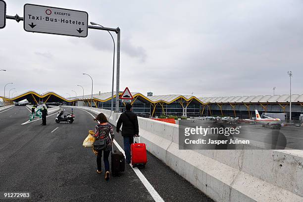 Airline passengers walk with their luggage to reach the terminal 4 building of Barajas airport on September 30, 2009 in Madrid, Spain. Some 1200...