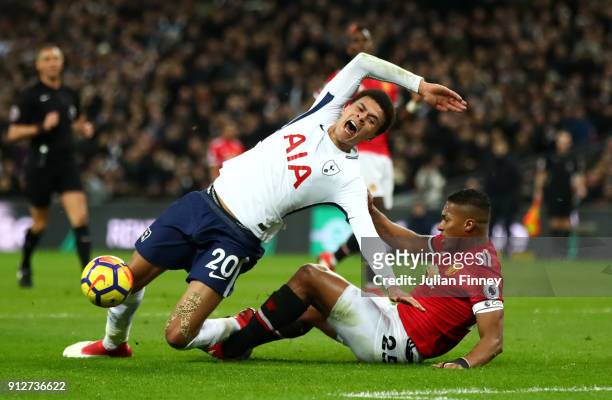 Dele Alli of Tottenham Hotspur is tackled by Antonio Valencia of Manchester United during the Premier League match between Tottenham Hotspur and...
