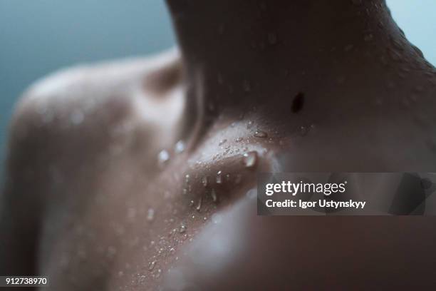 extreme close-up of woman enjoying a shower - clavicle stock pictures, royalty-free photos & images