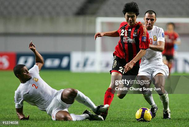 Ki Sung-Yueng of Seoul in action against Jawad Ahannach and Mohamed Husain of Umm-Salal during the AFC Champions League match between FC Seoul and...