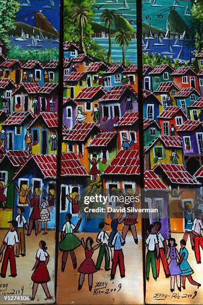 Local artwork shows the view of Pão de Açúcar, or Sugarloaf Mountain, behind a favella, a Brazilian slum, on sale at the Hippie Fair on August 23,...
