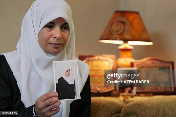 Palestinian mother shows a portrait of her daughter Hiba al-Natsheh, one of the 20 women who will be freed from Israeli jails in return for a video...