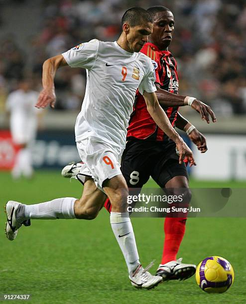 Magno Alves of Umm-Salal and Adilson Dos Santos of Seoul vie for the ball during the AFC Champions League match between FC Seoul and Umm-Salal at...