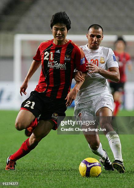 Ki Sung-Yueng of Seoul and Jawad Ahannach of Umm-Salal tussle for the ball during the AFC Champions League match between FC Seoul and Umm-Salal at...